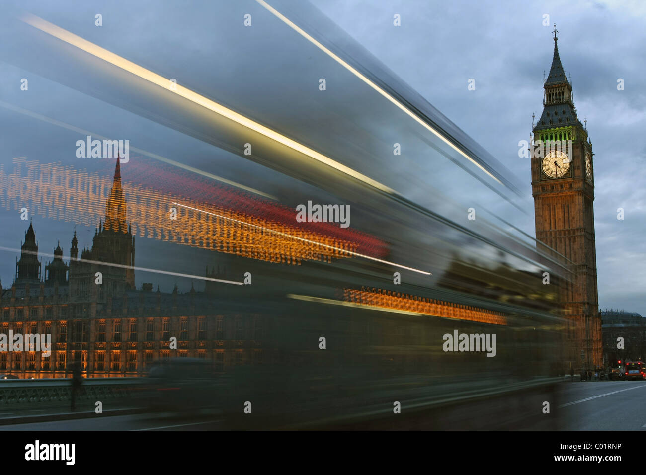 Un rosso London bus passando davanti alla Casa del Parlamento di sera Foto Stock