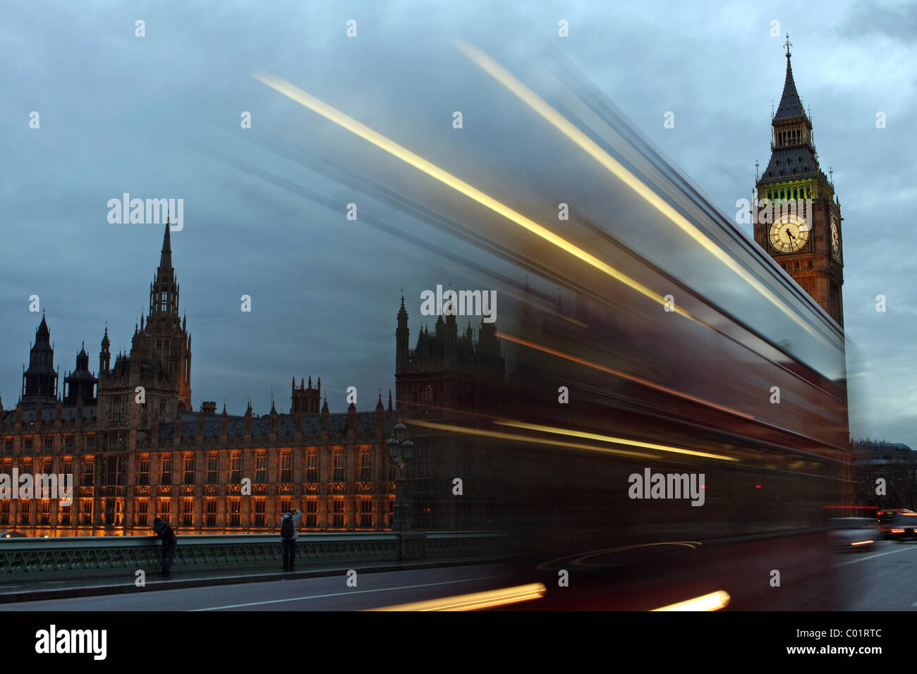 Un rosso London bus passando davanti alla Casa del Parlamento di sera Foto Stock