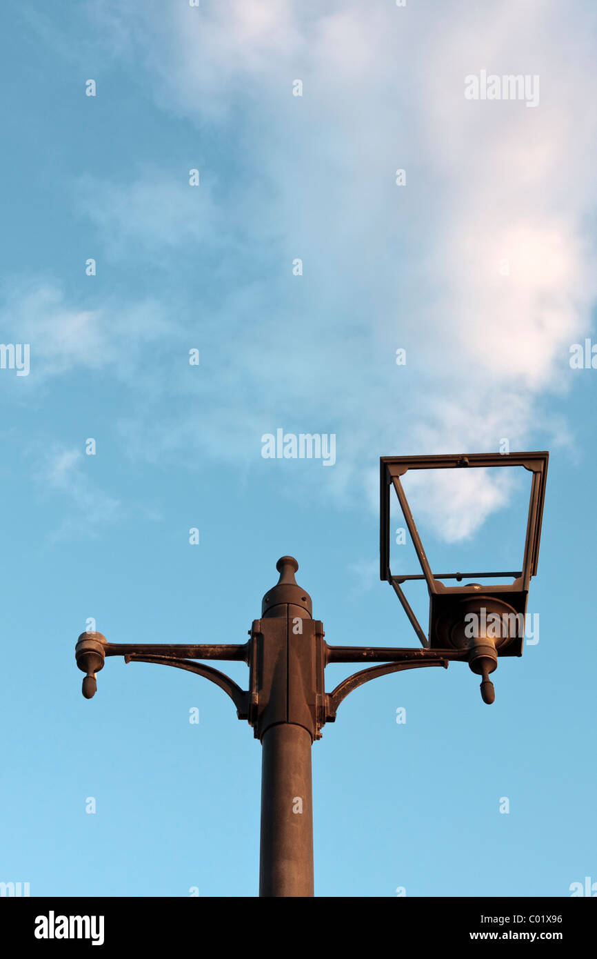 Un lampost rotto con il soffice nuvola dietro Foto Stock