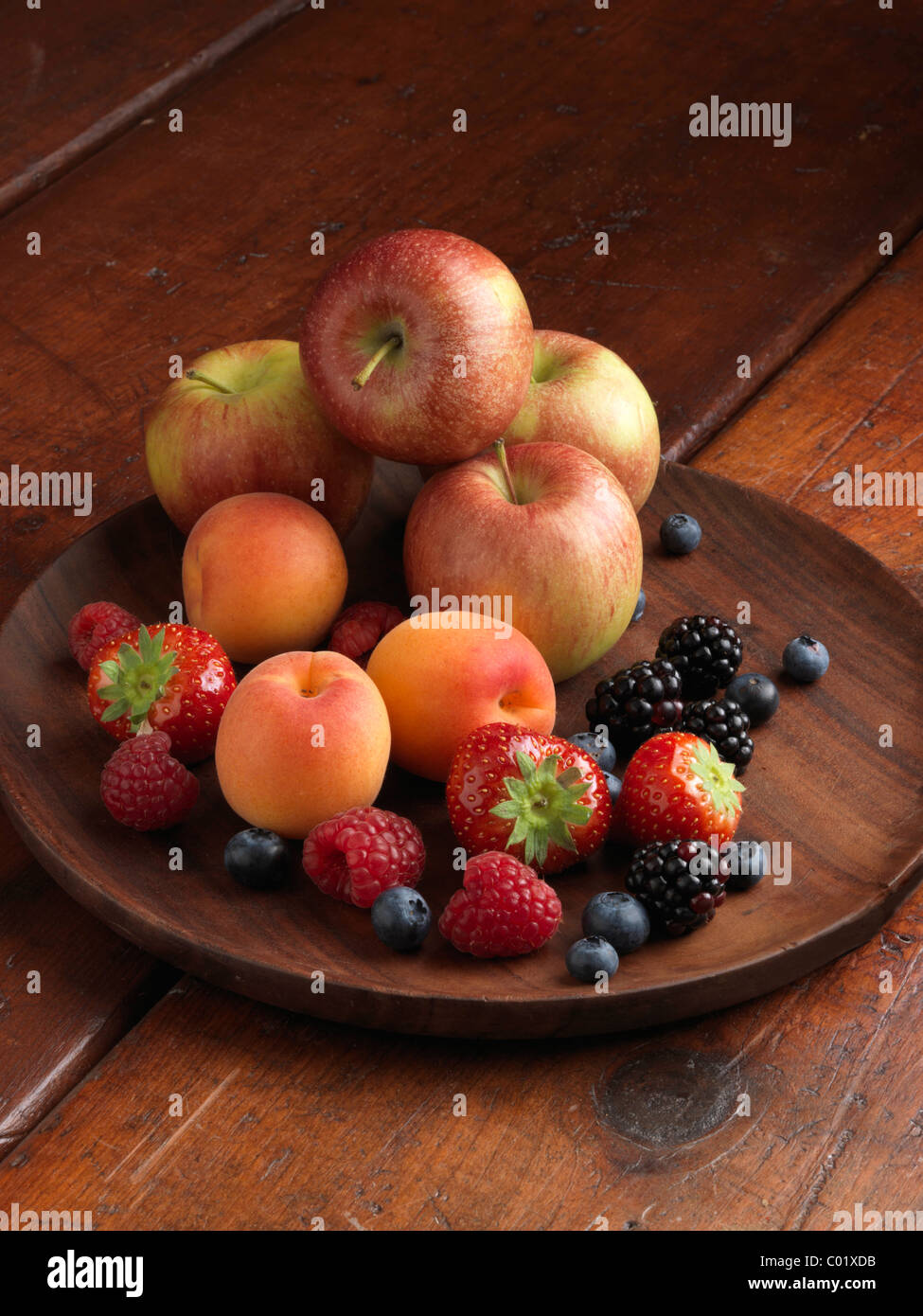 Un mucchio di frutta fresca Mele fragole mirtilli more lamponi e albicocche Foto Stock