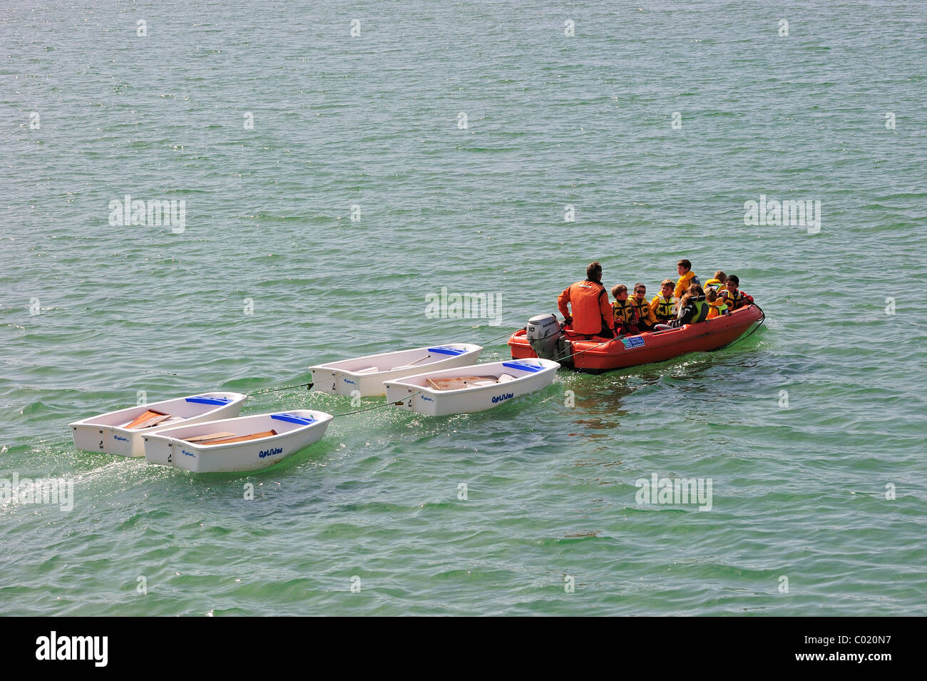 La scuola dei bambini con giubbotti di salvataggio in gommone nel corso di vela classe Foto Stock