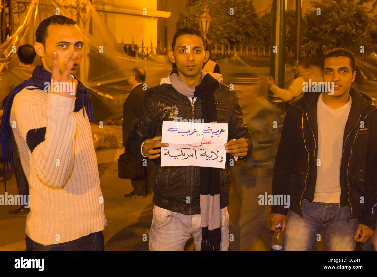 Anti-Mubarak i manifestanti con segno 'araba, arabo, non una provincia americana al di fuori dell' Assemblea popolare edificio di notte, il Cairo Foto Stock