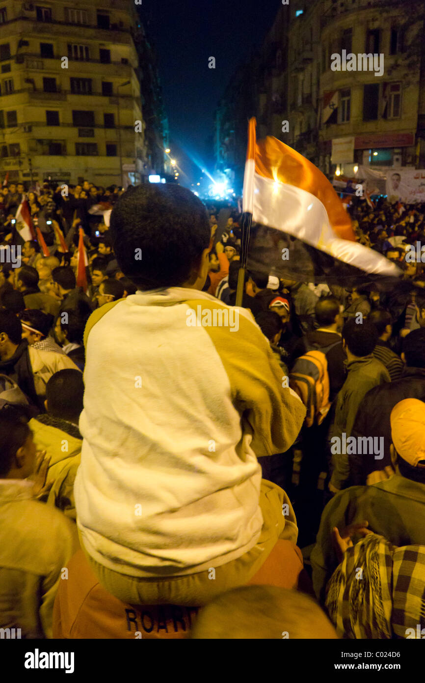 Ragazzo sventola bandiera e anti-Mubarak i manifestanti in piazza Tahrir al Cairo, Egitto Foto Stock