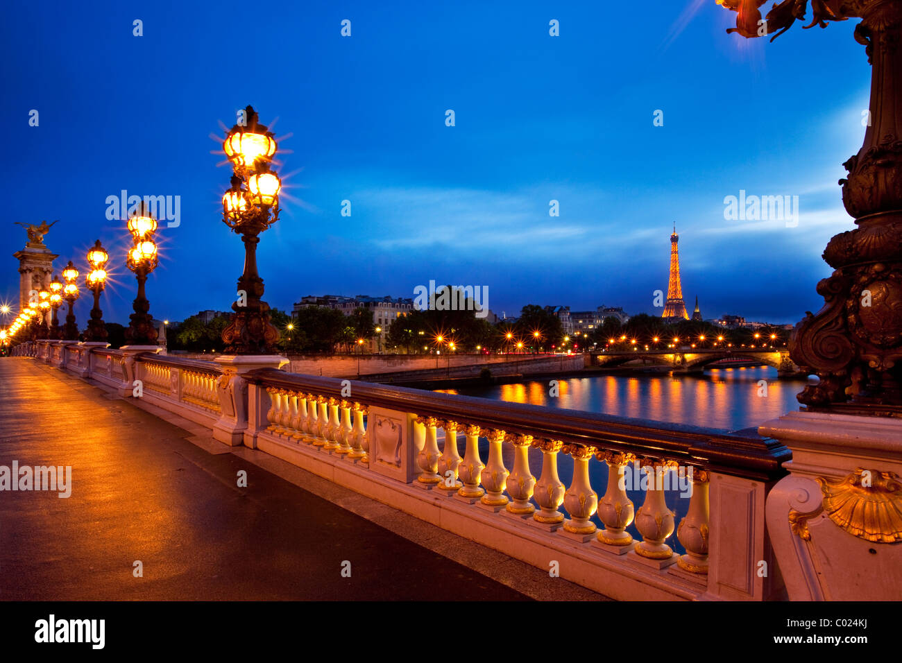 Lampade lungo Pont Alexandre III oltre il Fiume Senna con la torre Eiffel al di là, Parigi Francia Foto Stock
