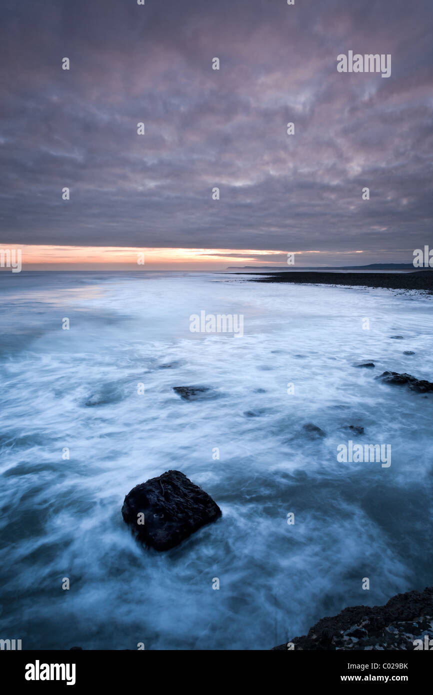 Surf di rotolamento all'alba guardando indietro a Huntcliff presso il South Gare Foto Stock