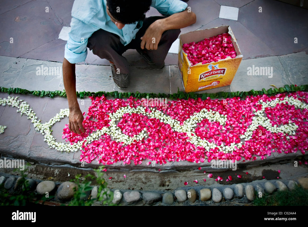 Un uomo prepara gli ornamenti floreali davanti a un matrimonio indiano a Nuova Delhi in India. Foto Stock
