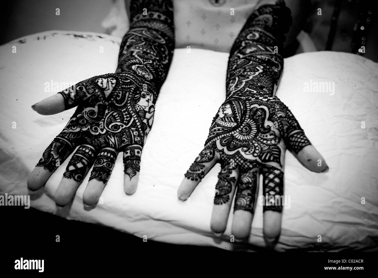 E sposa indiana con tradizionale henné (aka mehndi) vernice che copre le sue braccia e mani al suo giorno di nozze a Nuova Delhi in India. Foto Stock