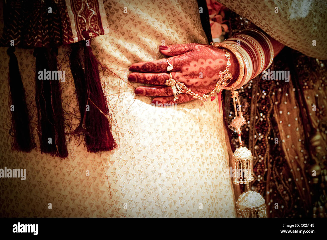 Una sposa indiana con tradizionale vernice all'henné (aka mehndi) che copre le braccia e le mani al suo giorno di nozze a Nuova Delhi in India. Foto Stock