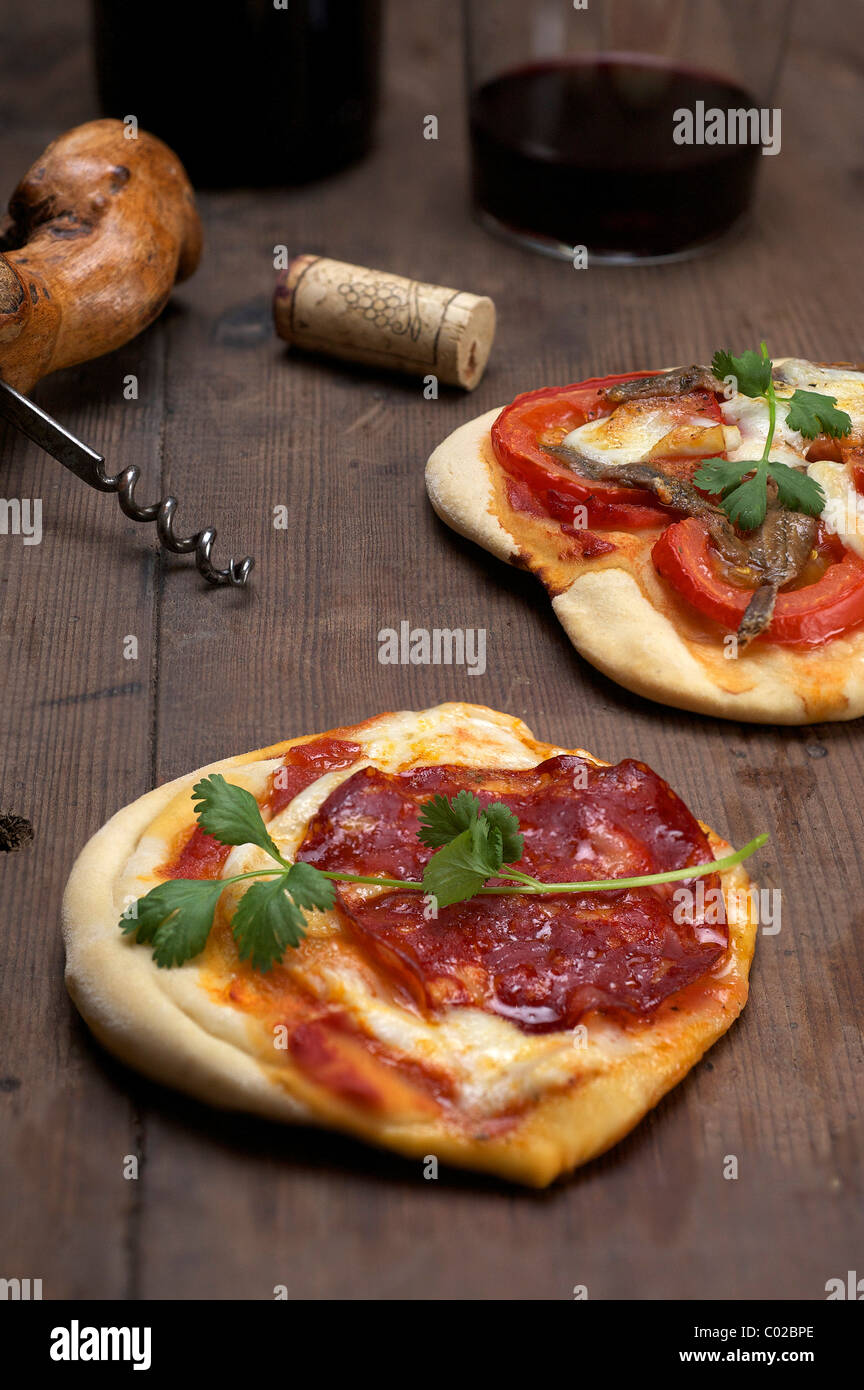 Pizzette, pizzette con mozzarella di bufala, il Chorizo e il coriandolo, anteriore e i pomodori e le acciughe, posteriore Foto Stock