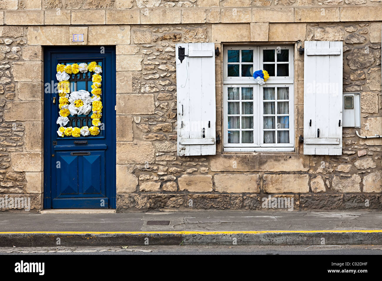 Porte e finestre con persiane decorate con fiori artificiali per festival Montignac Dordogne Francia Foto Stock