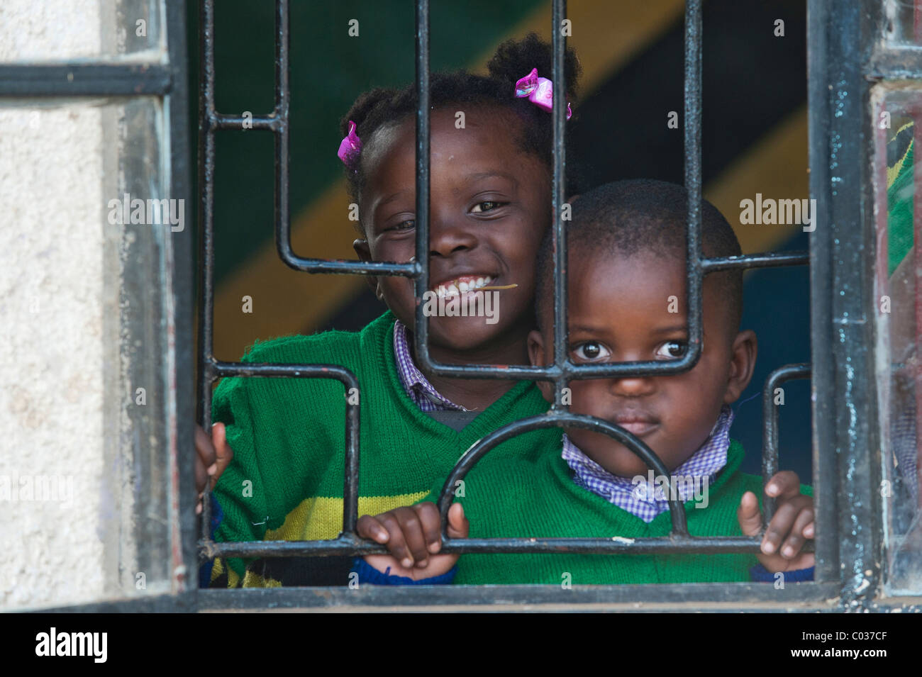 Un ragazzo e una ragazza, 4-5 anni, guardando attraverso finestre sbarrate, i bambini africani, ritratto, Tanzania Africa Foto Stock