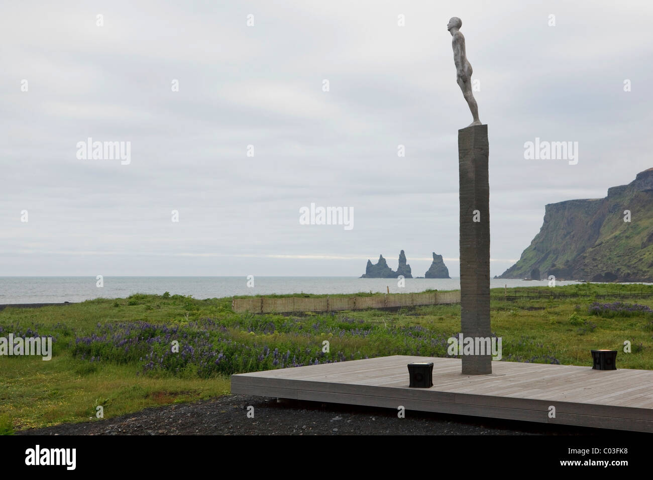 Scultura umano su un piedistallo sulle rupi costiere di Islanda, Vik, Islanda, Europa Foto Stock