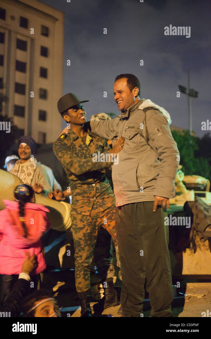 Civile egiziana e soldato dell'esercito abbracciando sulla parte superiore del serbatoio, Piazza Tahrir al Cairo, Egitto Foto Stock