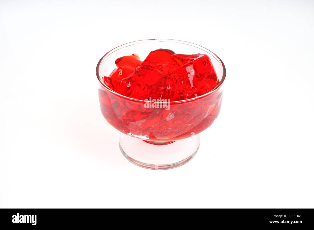 Fragola Jell-o gelatina in vetro piatto di servizio su sfondo bianco, isolata. Foto Stock