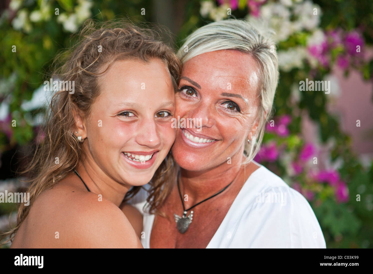 Ritratto di una madre con un tredici anni ragazza di fronte di fiori Foto Stock