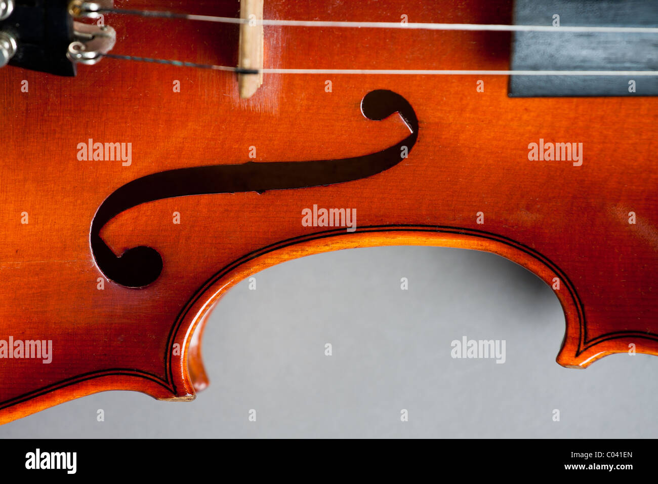 La 'C' bout e f foro di un violino classico o fiddle su sfondo grigio. Foto Stock