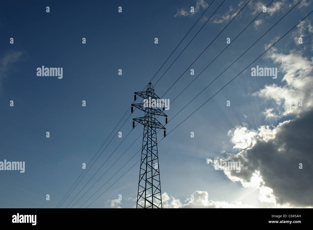 Alimentazione elettrica pilone e nuvoloso cielo blu Foto Stock