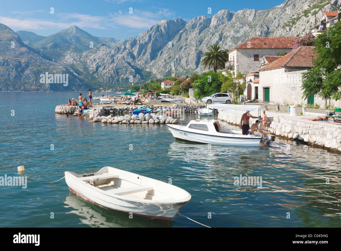 Barche ormeggiate e le persone sole, Dobrota, Boka Kotorska, Montenegro Foto Stock