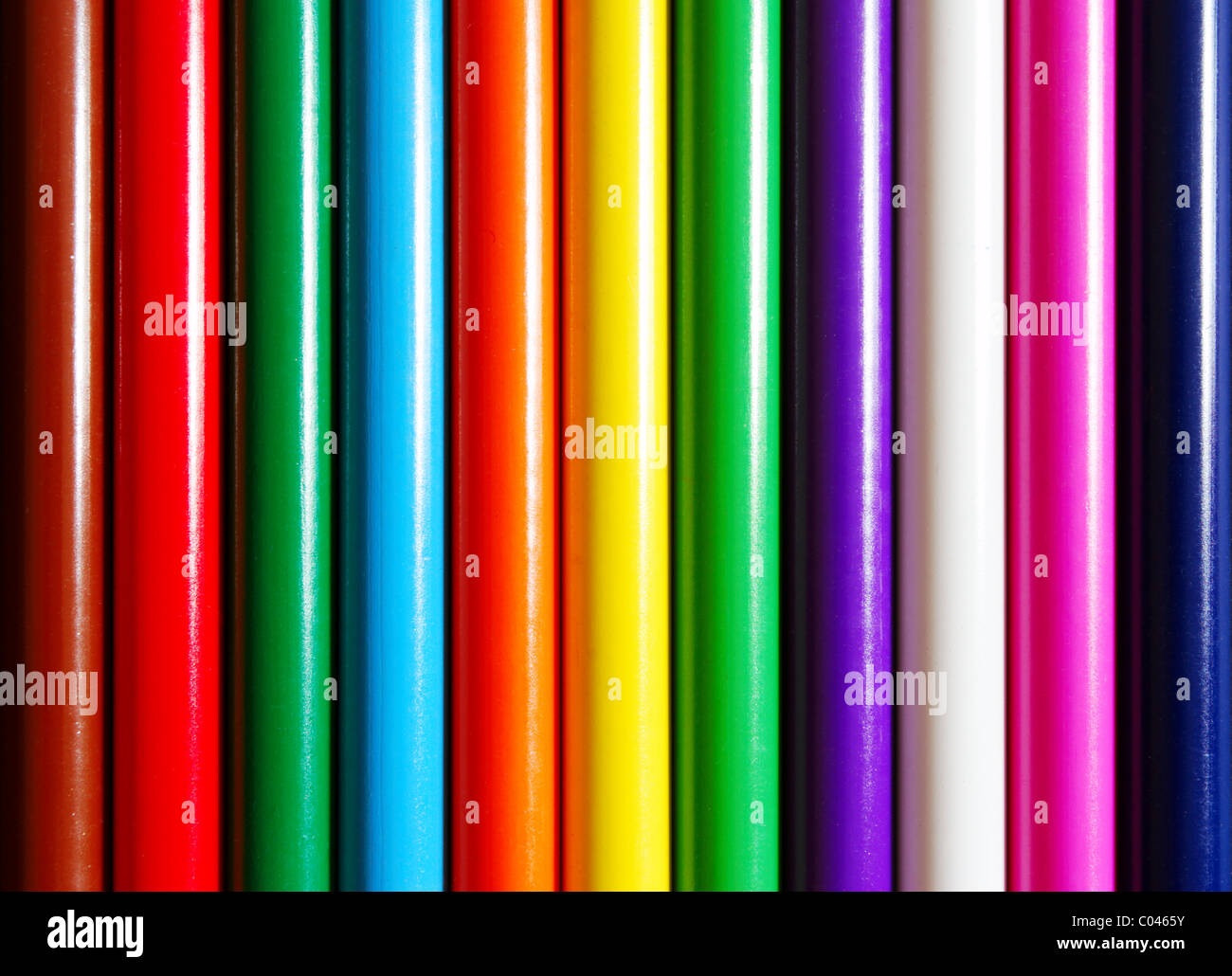 Matite di colore allineati fianco a fianco in condizioni di luce intensa Foto Stock