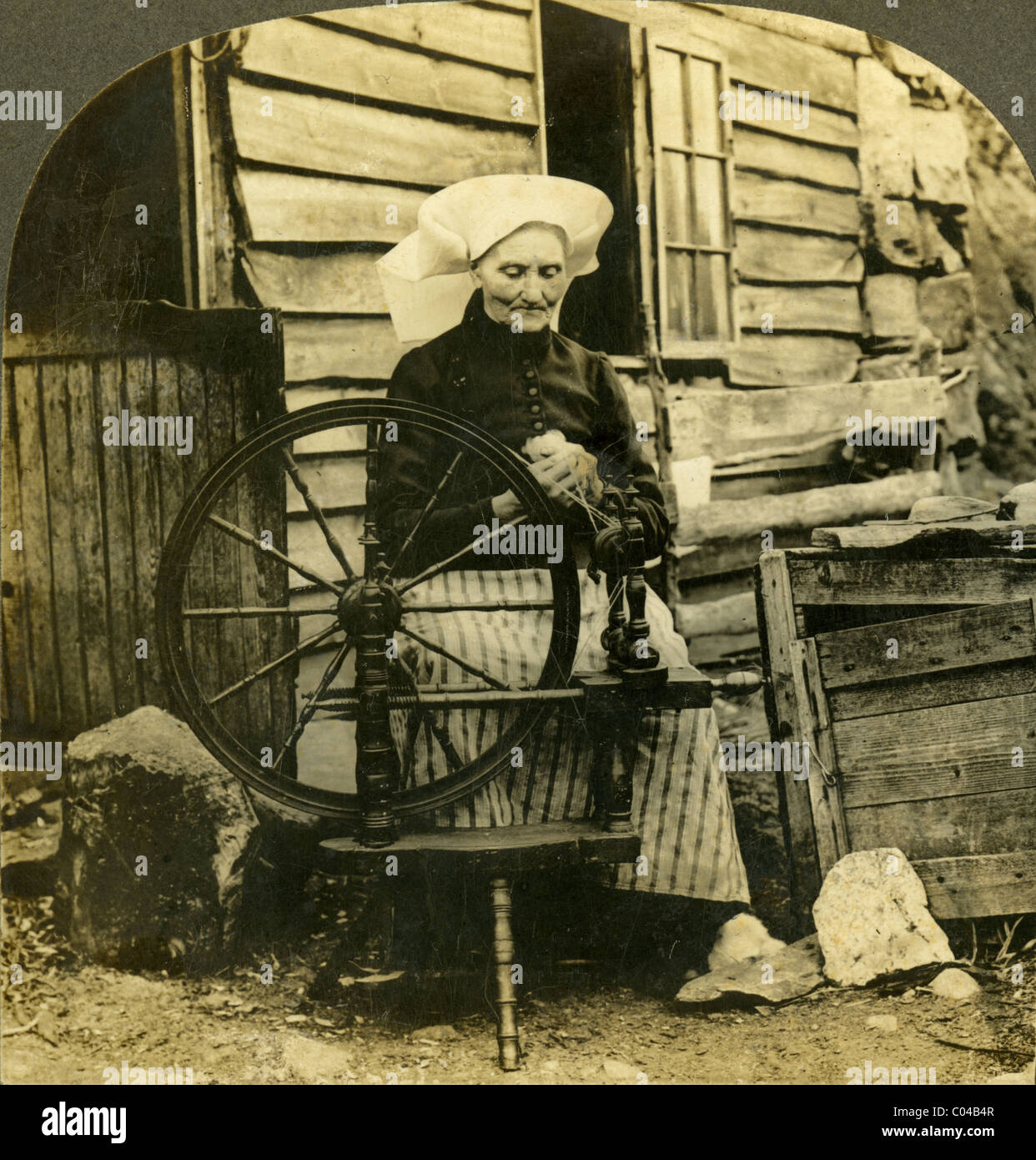 Circa 1910 stereoview card, 'Hardanger matrona con la sua ruota di filatura, Norvegia.". Foto Stock