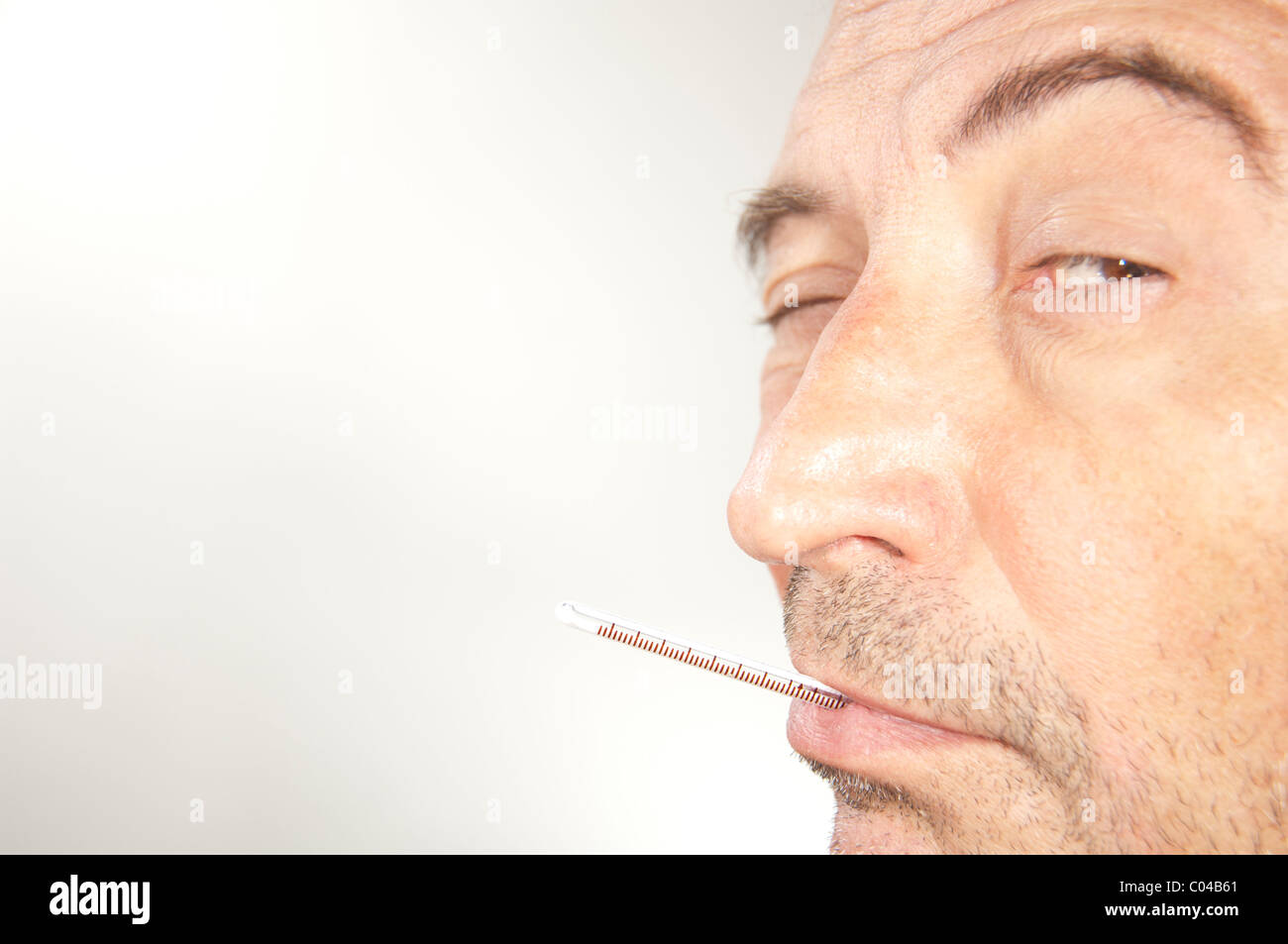 L'uomo con la febbre termometro nella sua bocca Foto stock - Alamy
