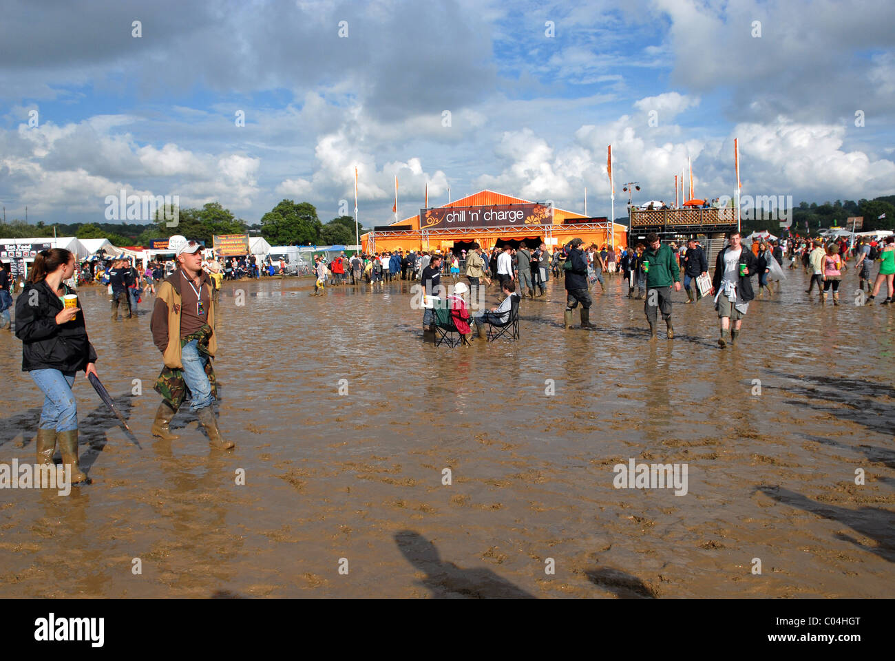 I frequentatori del festival a piedi attraverso il fango al festival di Glastonbury, Somerset, Regno Unito Foto Stock