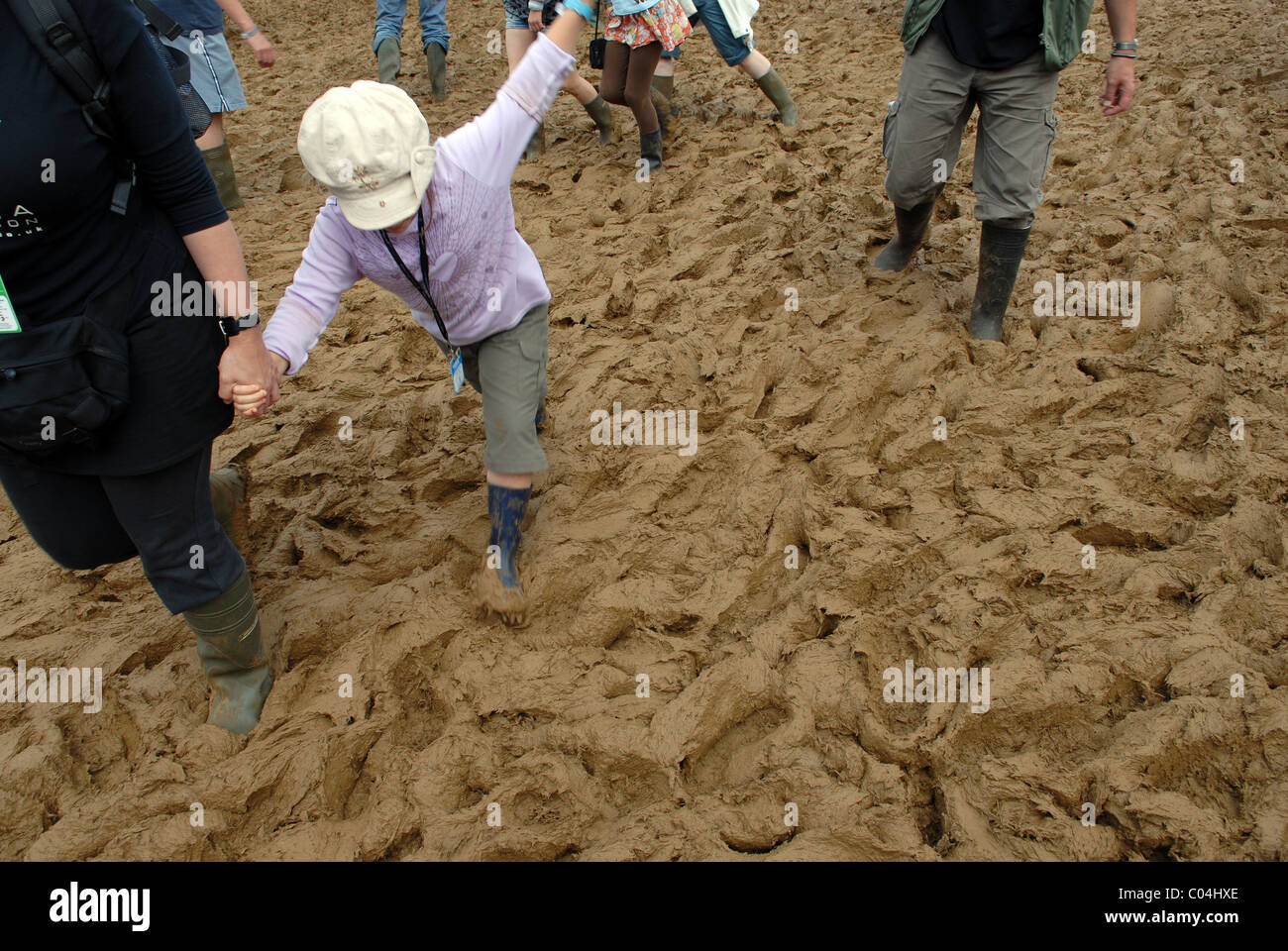 Bambino lottando attraverso il fango spesso DEL FESTIVAL WOMAD, Malmesbury, Wiltshire, Regno Unito Foto Stock