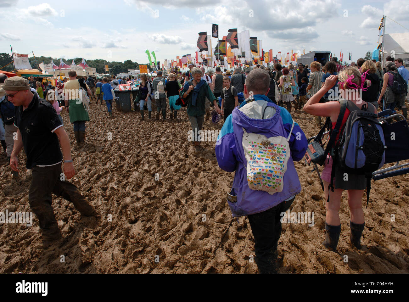 Persone che lottano attraverso il fango spesso DEL FESTIVAL WOMAD, Malmesbury, Wiltshire, Regno Unito Foto Stock