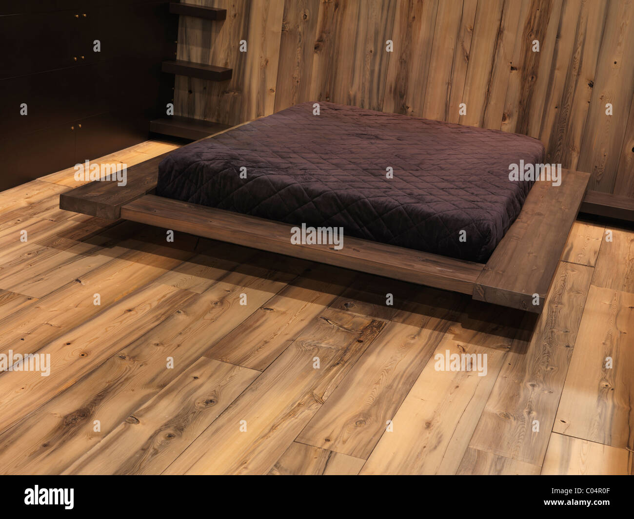 Elegante camera da letto in stile contemporaneo con pareti in legno e pavimento. Interior design display Foto Stock