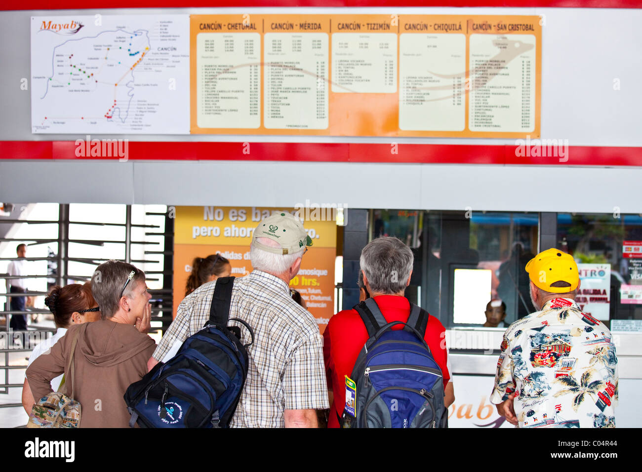 Escursionisti la lettura del calendario presso la stazione degli autobus, Cancun Quintana Roo, Messico Foto Stock