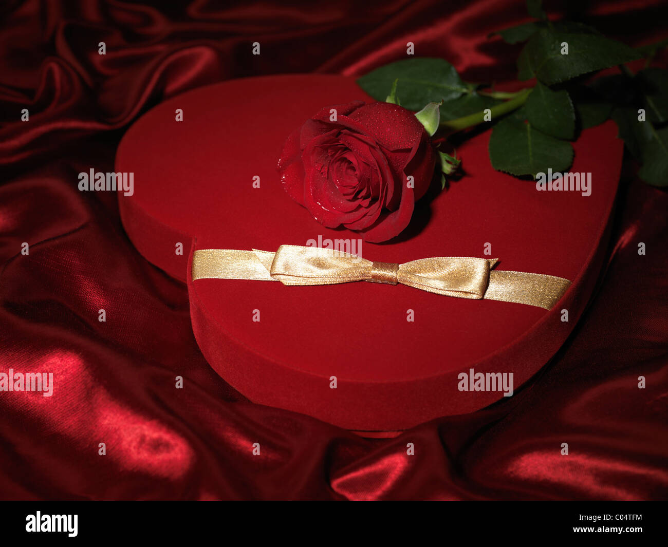 Cuore rosso a forma di scatola regalo e una rosa rossa Foto Stock
