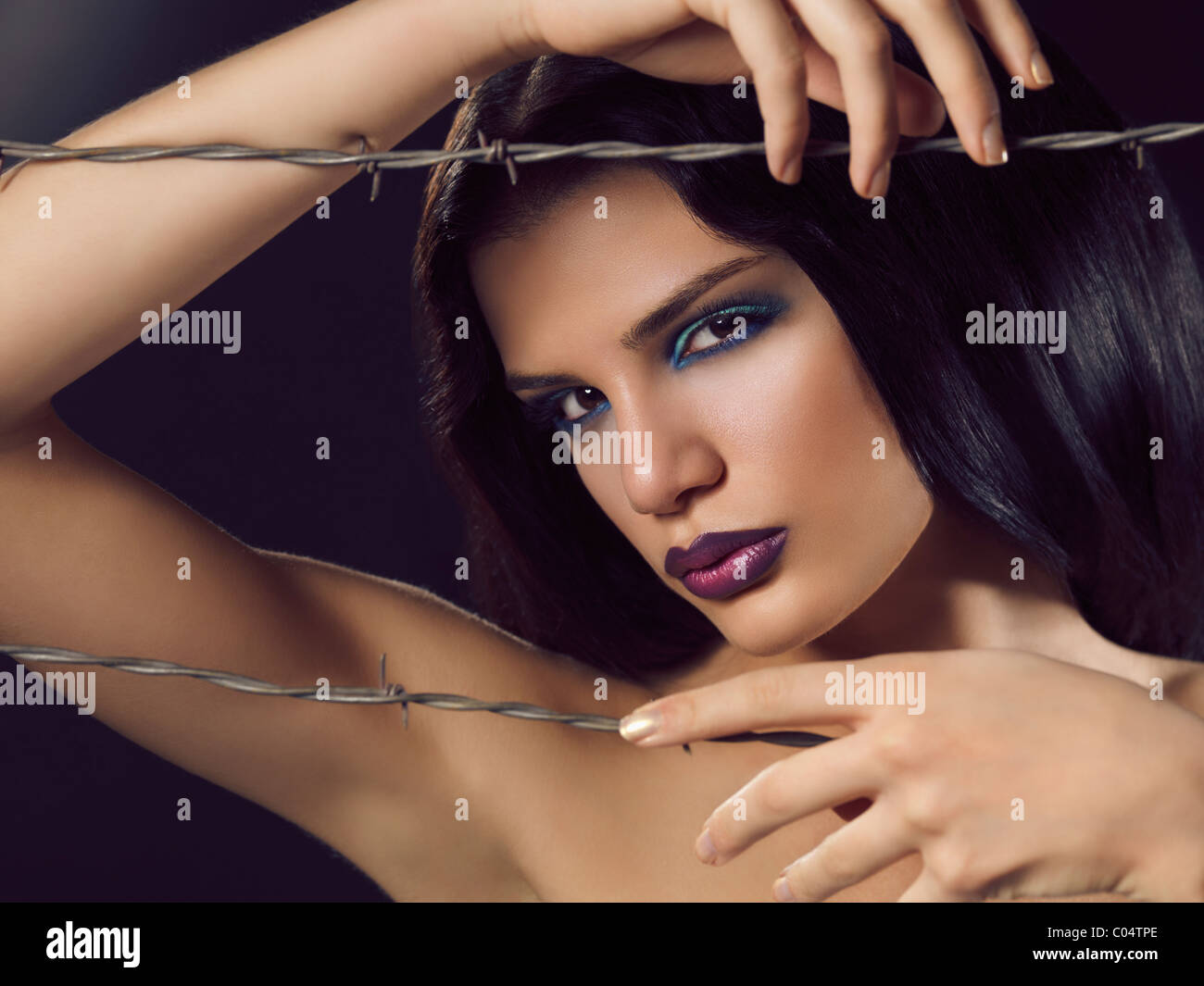 Artistico bellezza espressiva ritratto di una giovane donna bella dietro il filo spinato Foto Stock