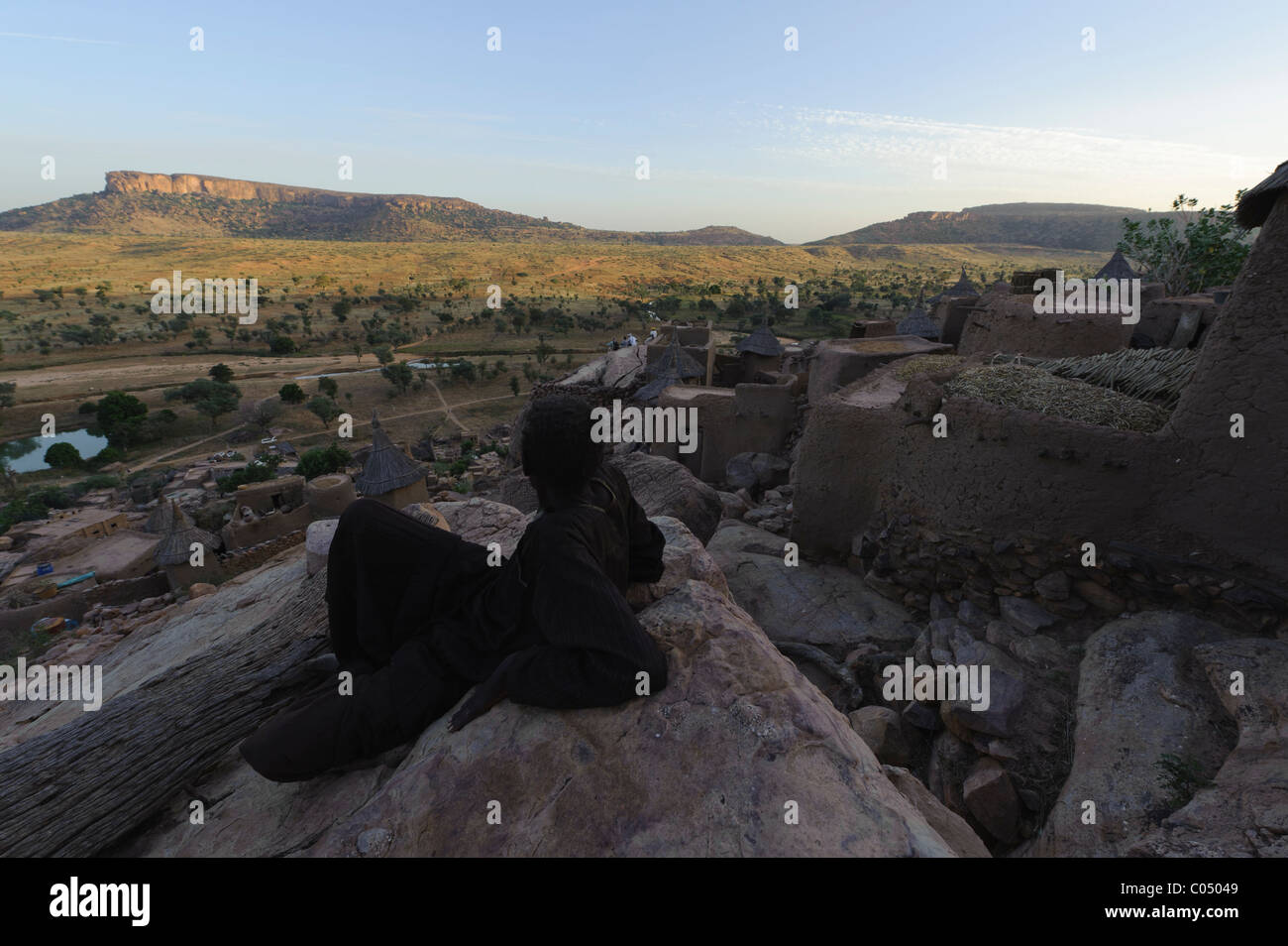 L uomo domina la pianura da una scogliera a Yendouma al villaggio Dogon di Youga Piri. Pays Dogon del Mali. Foto Stock