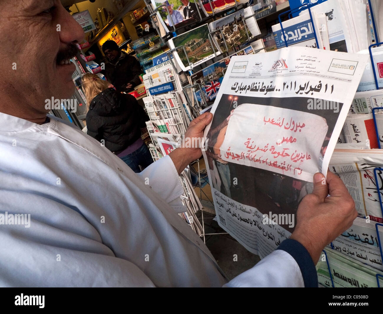 Uomo arabo lettura 12 febbraio 2011 quotidiano egiziano titolo Al-Ahram celebrando la vittoria per i manifestanti in Egitto, la Primavera araba Londra UK. KATHY DEWITT Foto Stock