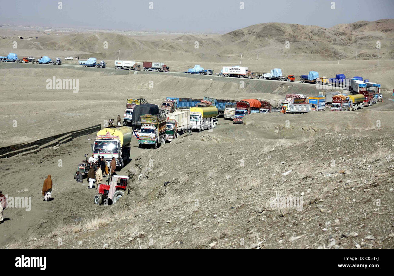 La NATO camionisti stare vicino ai loro veicoli che trasportano i materiali per le forze della NATO in Afghanistan meridionale come essi Foto Stock