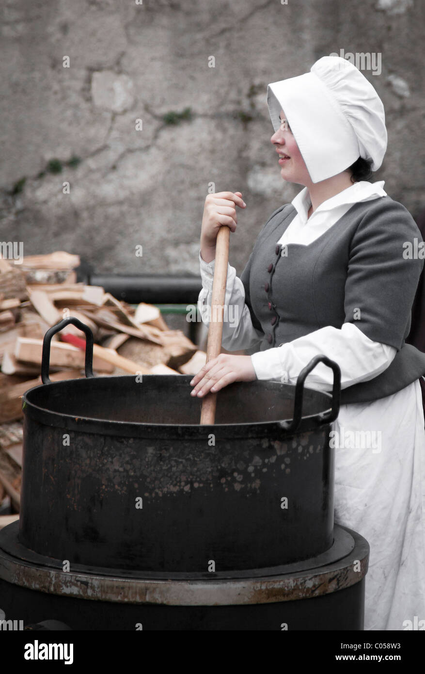 Una donna che suscita un calderone durante la Fête de l'Escalade a Ginevra in Svizzera Foto Stock