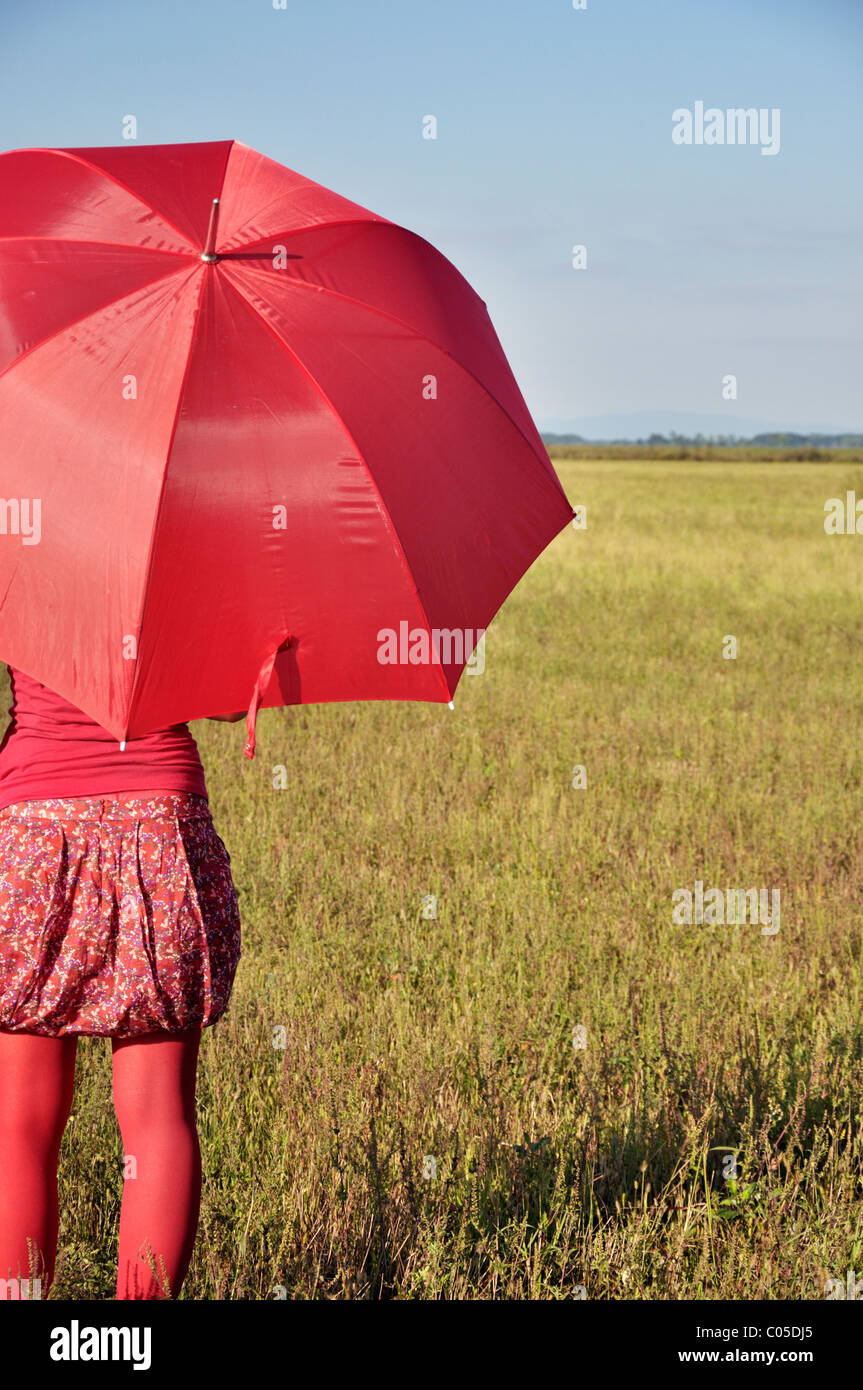 Giovane donna azienda Ombrellone rosso Foto Stock
