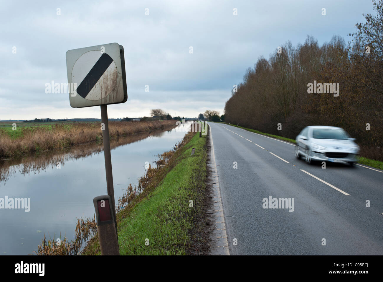 Il limite massimo di velocità segni Fenland sulla strada che corre a fianco di una piletta di scarico. Non vi sono barriere, la causa di alcuni strani incidenti se accelerando. Foto Stock