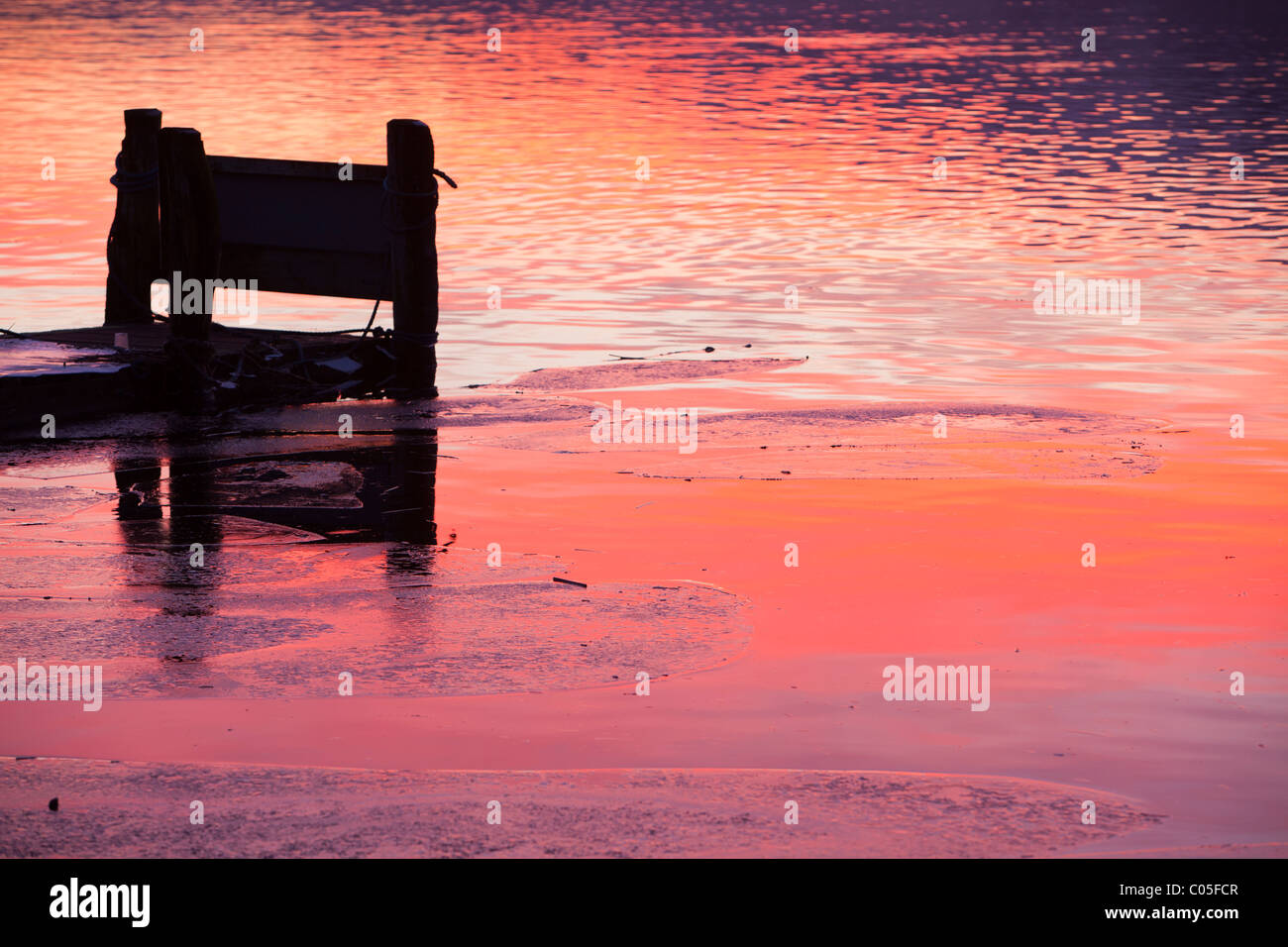 Waterhead in Ambleside sul Lago di Windermere, Lake District, UK, al tramonto con il ghiaccio sul lago. Foto Stock