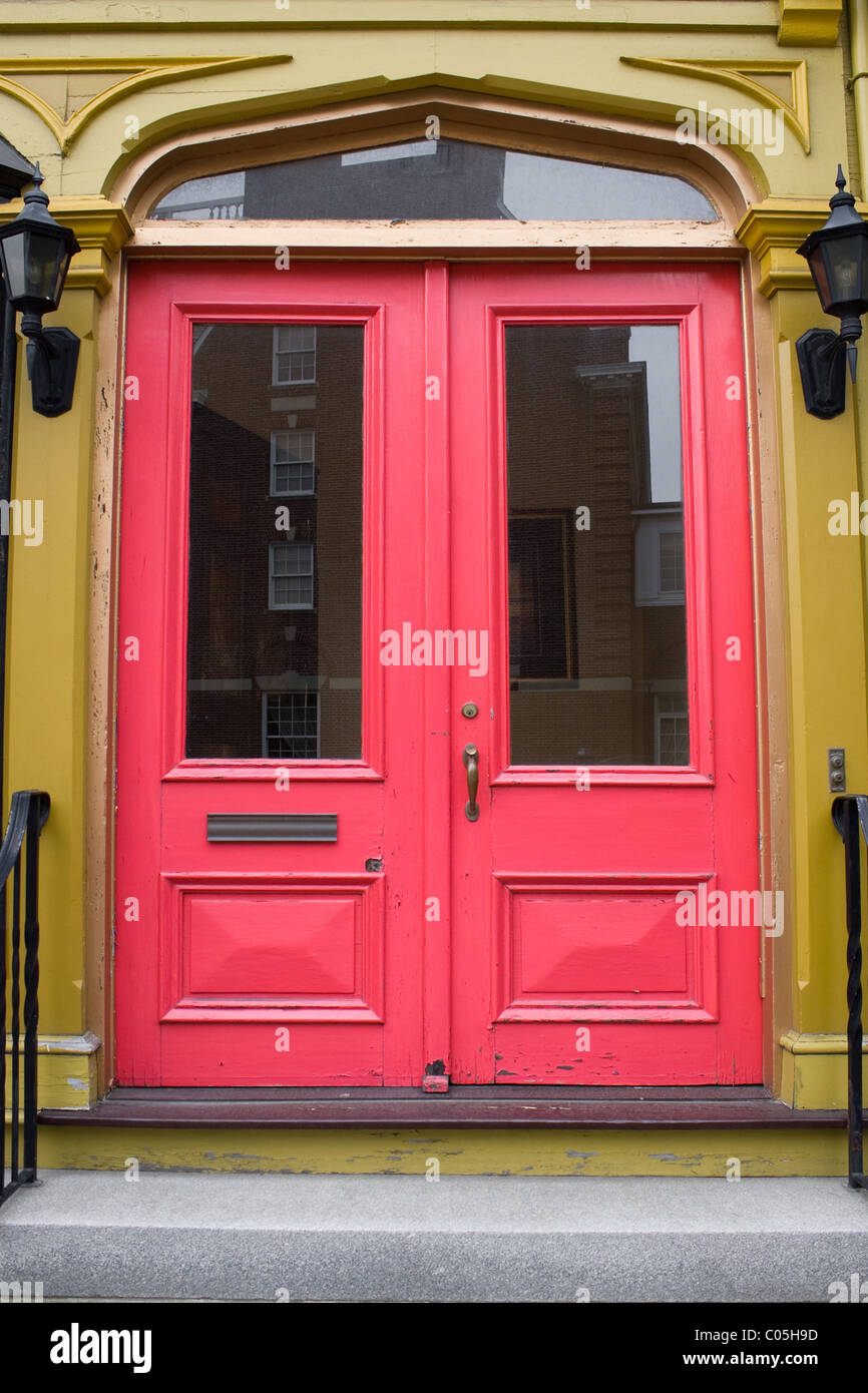 Un antico portale con red porte verniciate. Foto Stock
