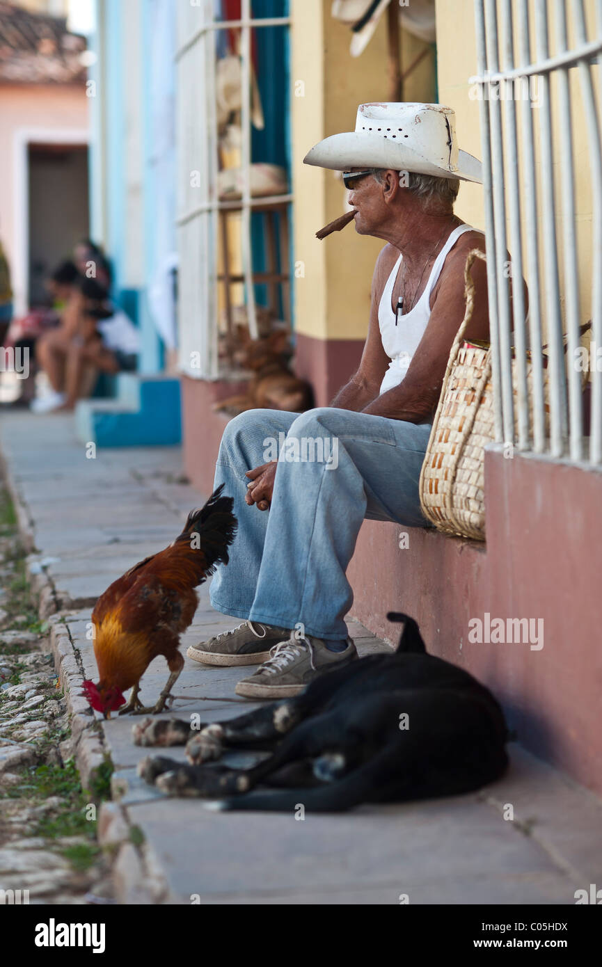 Uomo locale con pollo e cane Street scene Trinidad provincia di Sancti Spíritus, Cuba centrale Foto Stock