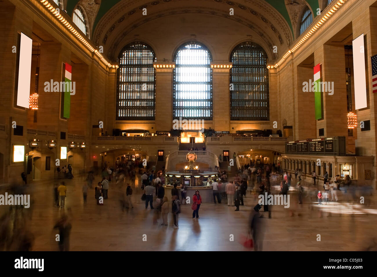 Foto temporizzata di persone sfocate che camminano attraverso la stazione ferroviaria Grand Central Terminal a New York City con una donna riconoscibile che sta da sola Foto Stock
