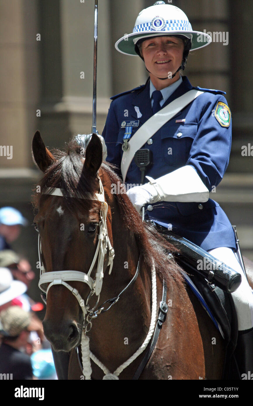 Una donna sorridente ufficiale di polizia a cavallo che partecipa alla parata di Natale attraverso le strade di Sydney, NSW, Australia Foto Stock