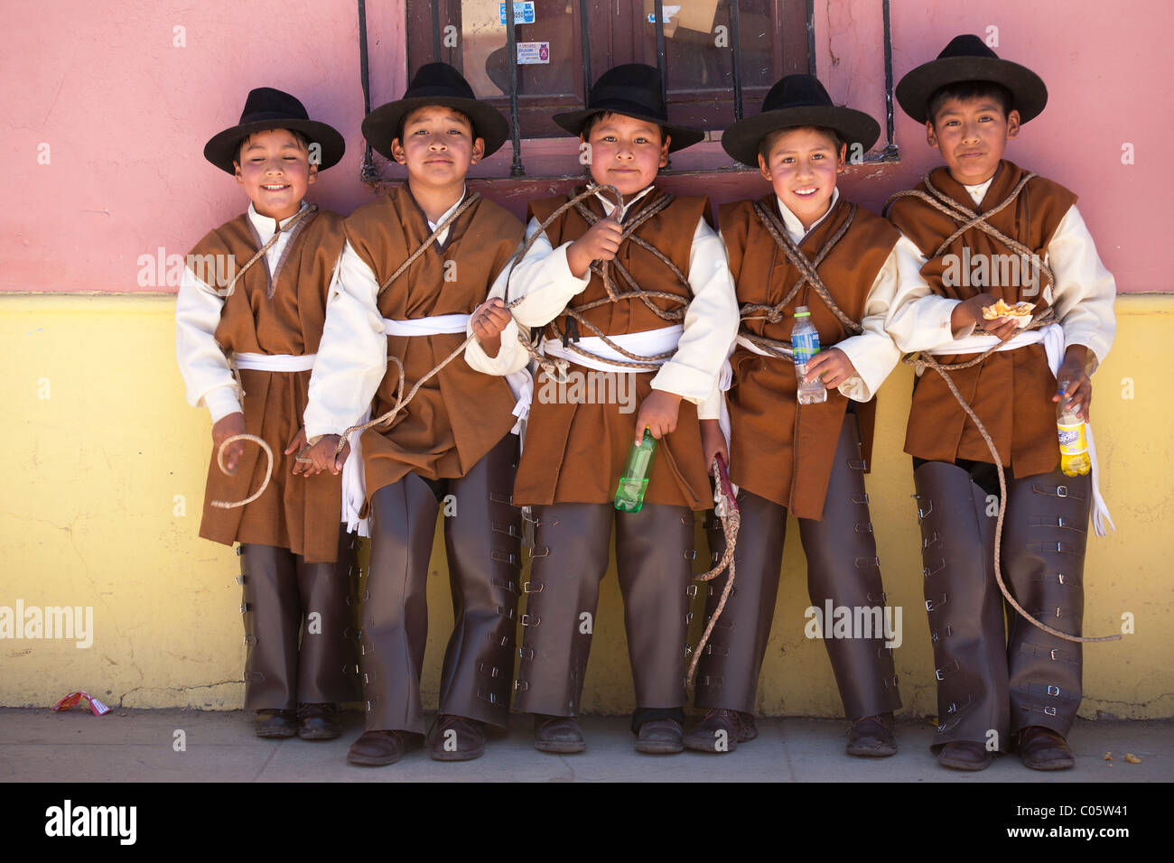 Scuola di cinque bambini vestiti in costume da cowboy mentre partecipa a Puno Sfilate Settimana Foto Stock