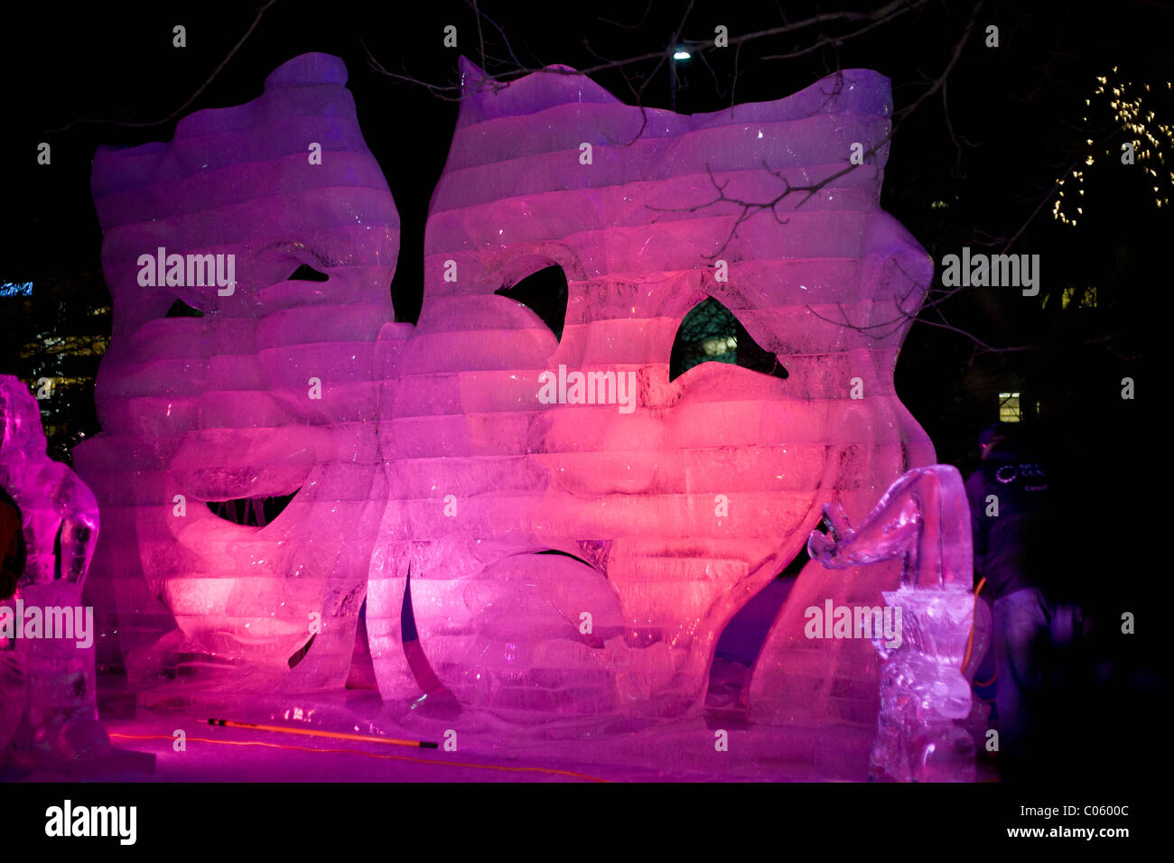 La commedia e la Tragedia di Ghiaccio rosso . Una scultura di ghiaccio delle famose maschere di notte, retroilluminato con il rosso e il blu lampade LED Foto Stock