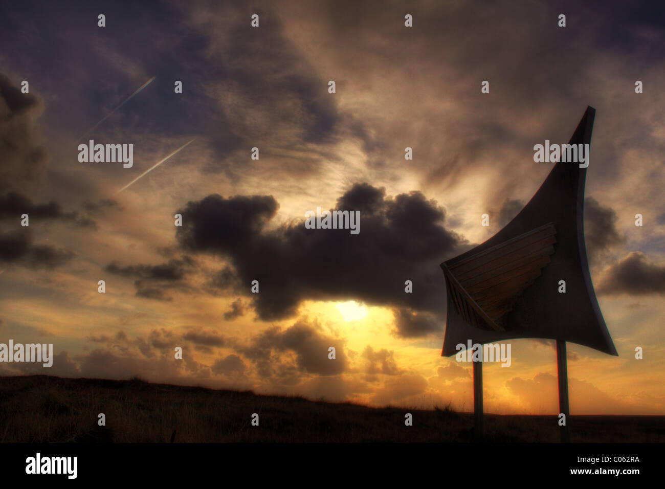 Scultura astratta di una imbarcazione scafo contro un tramonto spettacolare sky Foto Stock