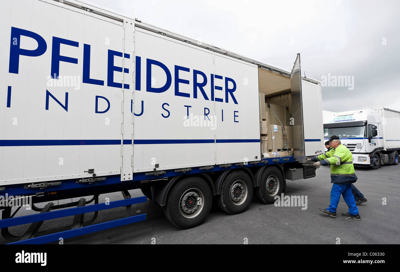 Dipendente chiudendo il rimorchio carico dopo il caricamento il carrello, Pfleiderer AG fabbrica presso la sede a Neumarkt Foto Stock