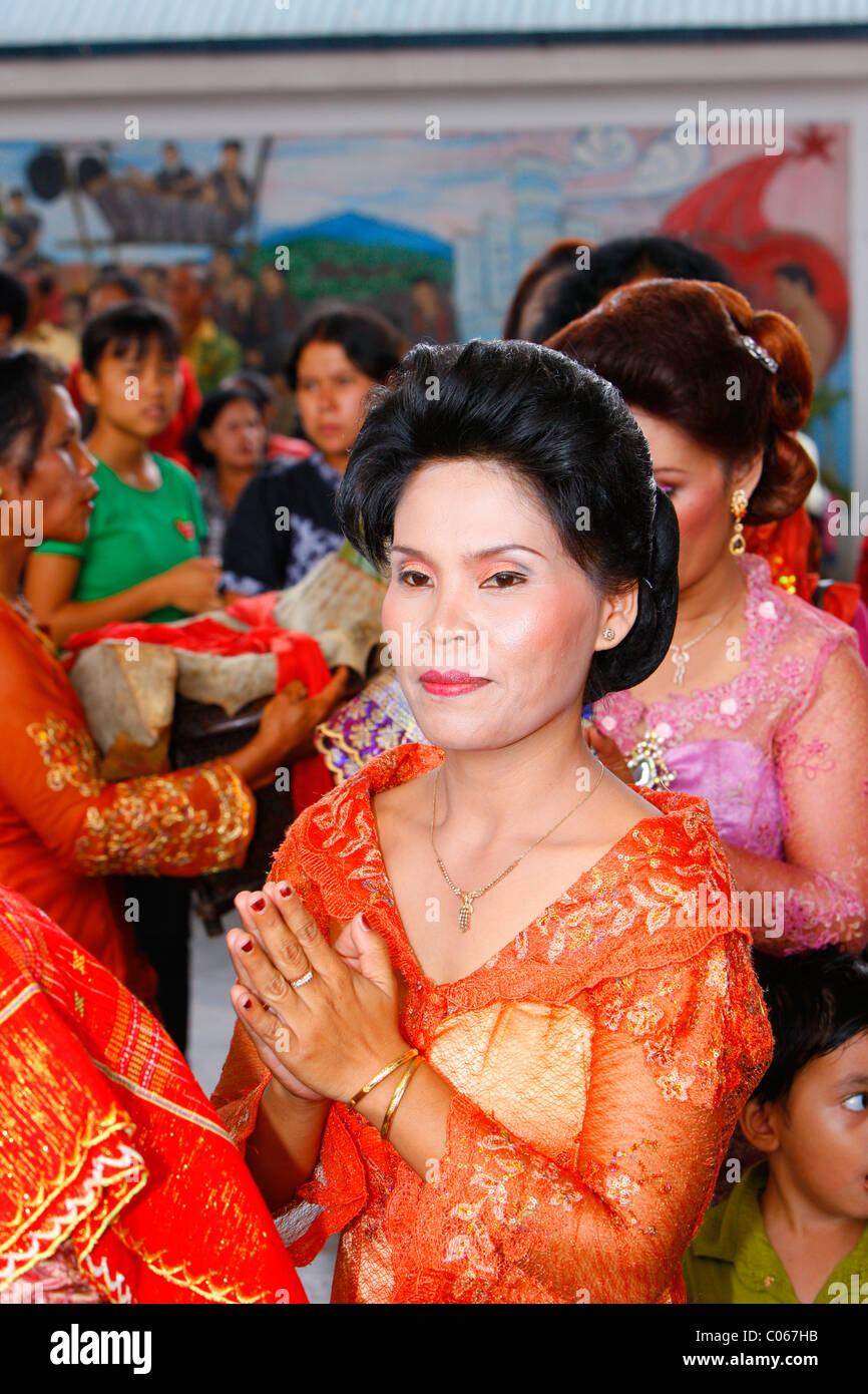 Donna con le sue mani tenute insieme, gli ospiti a una cerimonia di nozze, Siantar, Batak regione, Sumatra, Indonesia, Asia Foto Stock