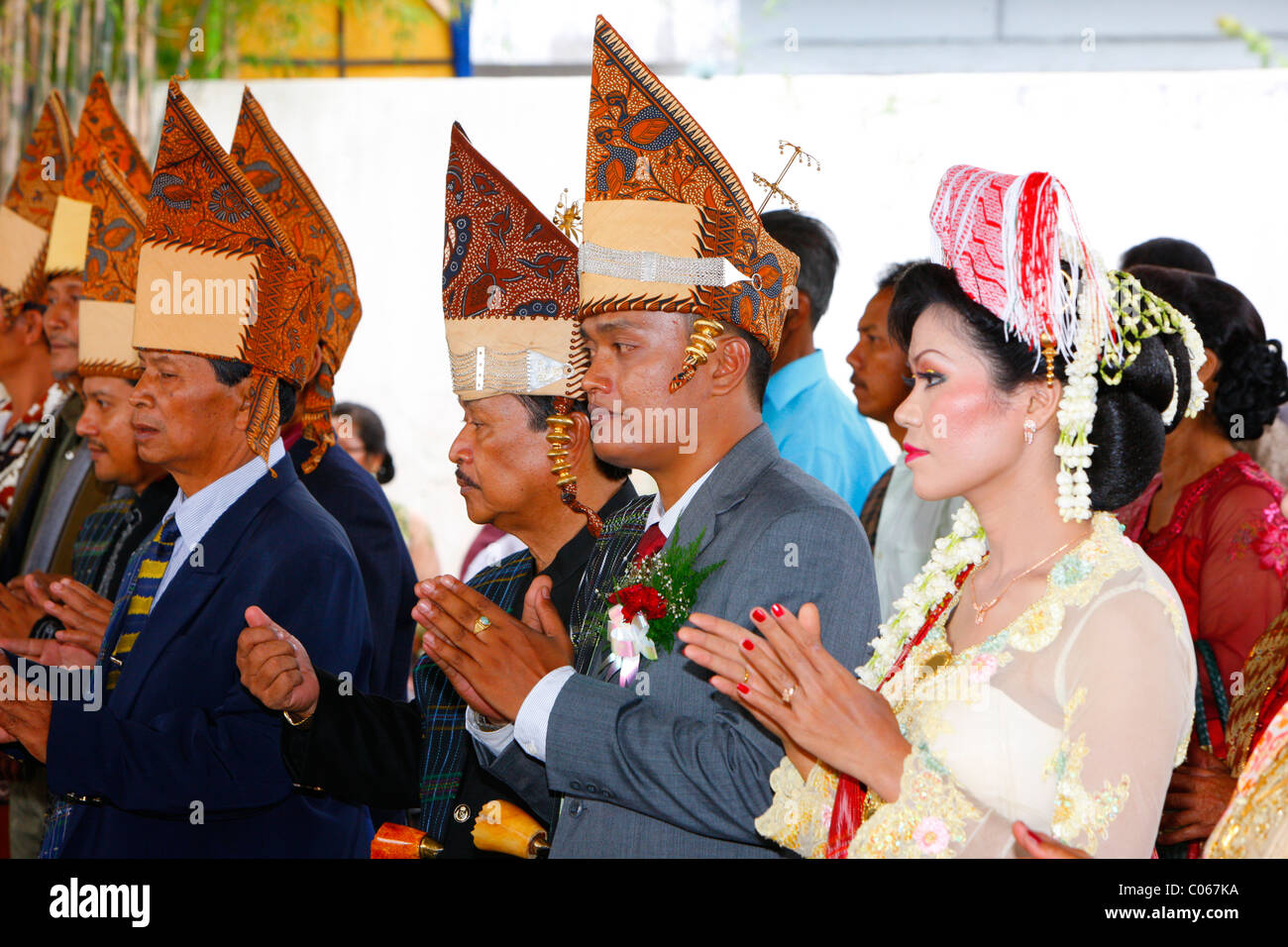 Sposa e lo sposo con le loro mani tenute insieme, cerimonia di nozze, Siantar, Batak regione, Sumatra, Indonesia, Asia Foto Stock