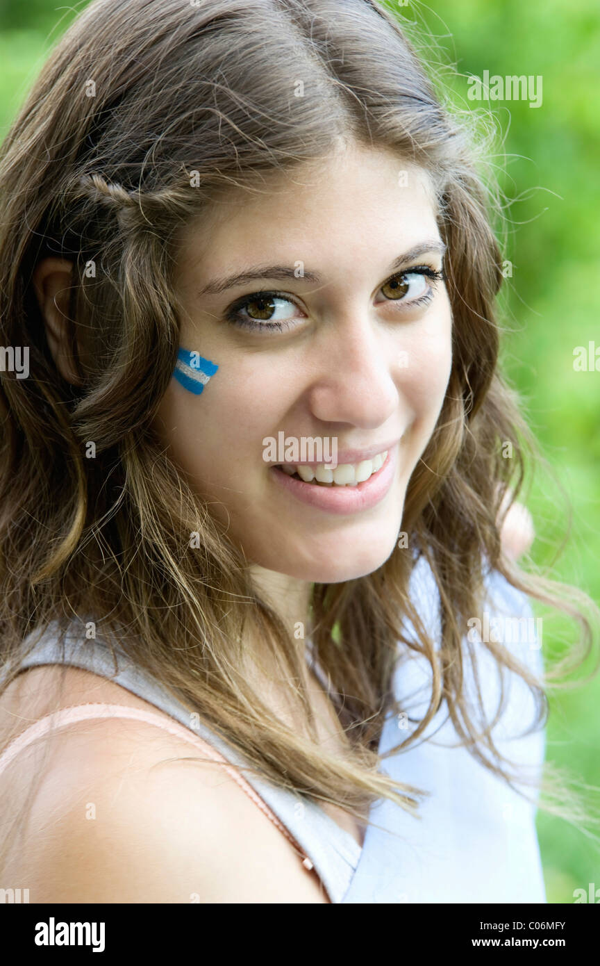 Ritratto di una giovane donna argentina con la bandiera argentina sulla sua guancia Foto Stock